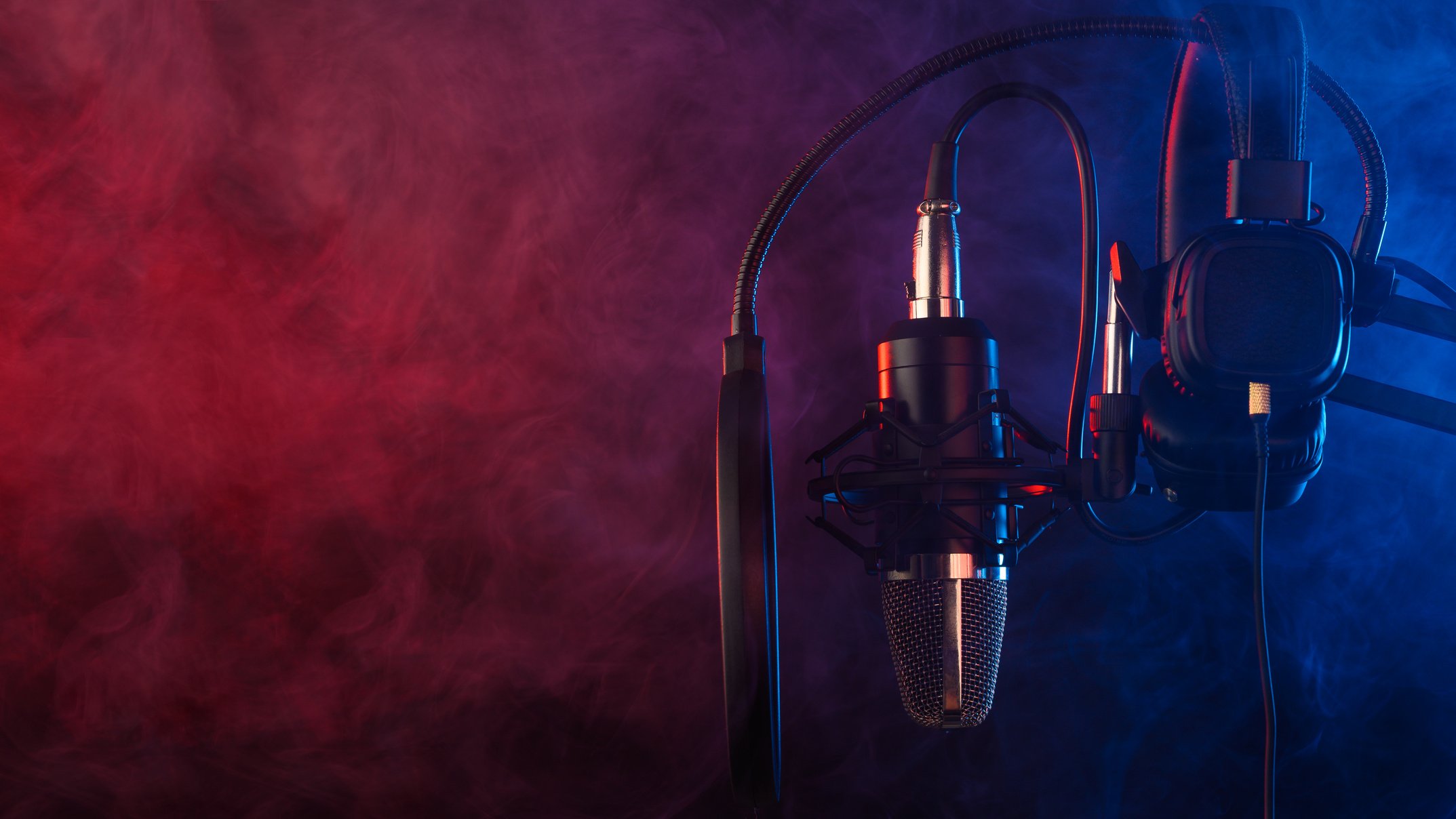 Studio microphone and headphones on mic stand against .Color disco background. Vocals and radio, podcasts.